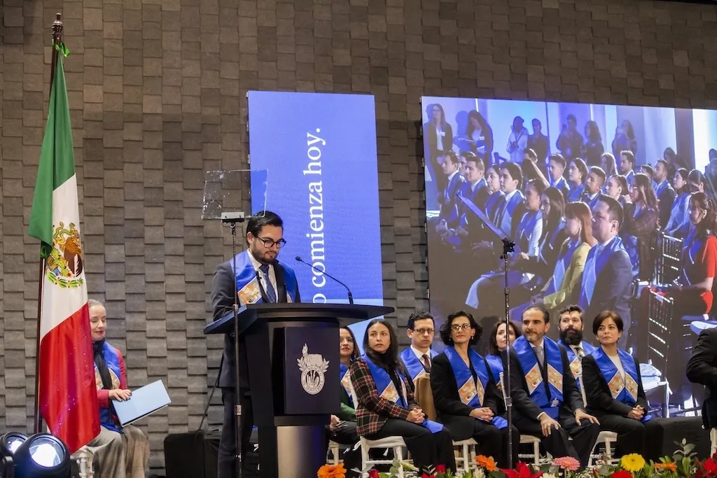 Héctor Sauza hablando desde el podio en una ceremonia académica