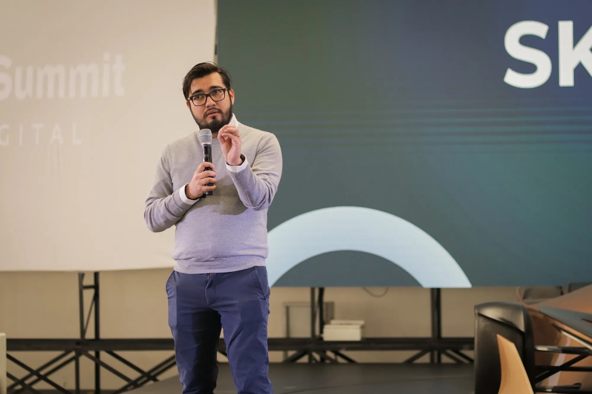 Héctor Sauza con micrófono durante una conferencia en un summit de innovación